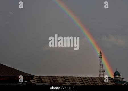 Un arcobaleno appare dopo una leggera pioggia su una moschea nella città di Sopore, nel distretto di Baramulla Jammu e Kashmir India, il 19 luglio 2021. (Foto di Nasir Kachroo/NurPhoto) Foto Stock