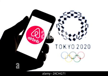 In questa foto è riportato un logo Airbnb, Inc. Visualizzato su uno smartphone con il logo dei Giochi Olimpici di Tokyo 2020 sullo sfondo. (Foto di DAX Images/NurPhoto) Foto Stock