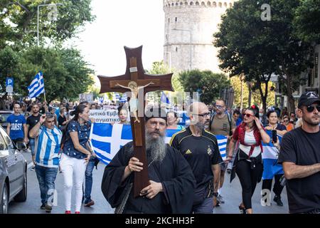 Un sacerdote tiene una croce durante una dimostrazione contro il vaccino obbligatorio si è tenuta a Salonicco e ad Atene in Grecia mercoledì 21 luglio 2021. Una settimana dopo la massiccia protesta contro la vaccinazione obbligatoria, la campagna anti-vaxx continua con un grande gruppo che protesta nelle strade della città di Salonicco. La protesta è stata organizzata attraverso i social media da credenti anti-vaccinazioni. Secondo il gruppo hanno partecipato più di 40,000 persone, mentre la polizia ha stimato ufficiosamente circa 15,000 persone che hanno partecipato alla manifestazione. Come sta passando il governo greco Foto Stock