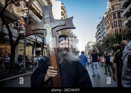 Un sacerdote tiene una croce durante una dimostrazione contro il vaccino obbligatorio si è tenuta a Salonicco e ad Atene in Grecia mercoledì 21 luglio 2021. Una settimana dopo la massiccia protesta contro la vaccinazione obbligatoria, la campagna anti-vaxx continua con un grande gruppo che protesta nelle strade della città di Salonicco. La protesta è stata organizzata attraverso i social media da credenti anti-vaccinazioni. Secondo il gruppo hanno partecipato più di 40,000 persone, mentre la polizia ha stimato ufficiosamente circa 15,000 persone che hanno partecipato alla manifestazione. Come sta passando il governo greco Foto Stock