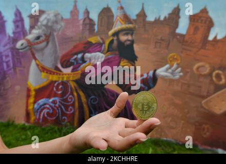 Un netizen tiene un Bitcoin commemorativo fisico di fronte ad un murale a Cracovia. Giovedì 22 luglio 2021, a Cracovia, Malopolskie Voivodato, Polonia. (Foto di Artur Widak/NurPhoto) Foto Stock