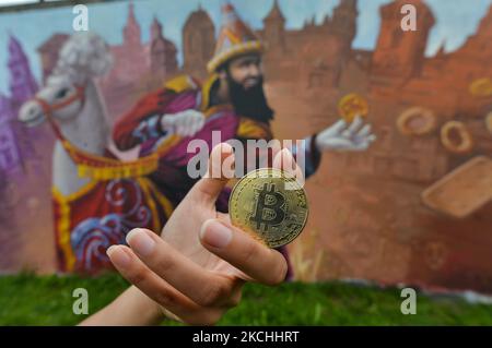 Un netizen tiene un Bitcoin commemorativo fisico di fronte ad un murale a Cracovia. Giovedì 22 luglio 2021, a Cracovia, Malopolskie Voivodato, Polonia. (Foto di Artur Widak/NurPhoto) Foto Stock