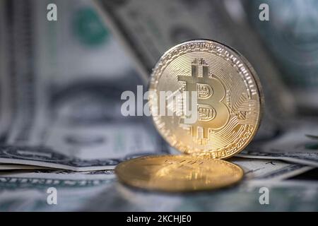 Bitcoin illustrazione fisica moneta d'oro sulle banconote in dollari degli Stati Uniti. Rappresentazioni visive del Bitcoin digitale Cryptocurrency con la fattura USD. Bitcoin con il simbolo BTC, XBT è una popolare moneta digitale che ha mostrato crescita ed è ampiamente diffusa, accettata da banche, mercati e altri servizi e negozi come modalità di pagamento. Il tasso di cambio oggi per 1 bitcoin blockchain è di 32,287 dollari USA. Il valore del bitcoin della criptovaluta è salito al massimo record nel 2021, raggiungendo i $63.000 dollari secondo i media finanziari americani. Salonicco, Grecia il 23 luglio 2021 (Foto di Nicolas e Foto Stock