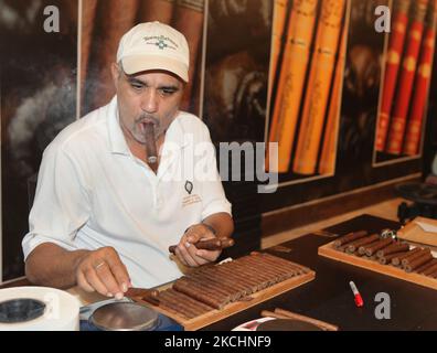 Lavoratore fuma un sigaro grande mentre pesa sigari appena arrotolati e li controlla per assicurare la qualità alla fabbrica LaFlor Dominicana Cigar a la Romana, Repubblica Dominicana, il 19 dicembre 2012. (Foto di Creative Touch Imaging Ltd./NurPhoto) Foto Stock