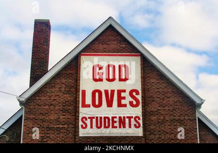 Il segno 'Dio ama gli studenti' sul lato di una chiesa in Ontario, Canada. (Foto di Creative Touch Imaging Ltd./NurPhoto) Foto Stock