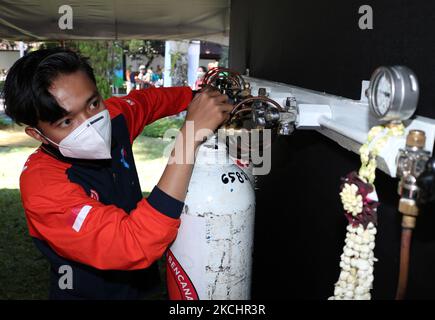 I lavoratori gestiscono bombole di ossigeno a carica libera presso il centro di distribuzione BPBD per i residenti esposti al coronavirus Covid-19 nel processo di auto-isolamento a casa a Malang, giava orientale, il 26 luglio 2021, poiché le forniture di ossigeno della nazione sono prioritarie verso i pazienti di coronavirus Covid-19, precedentemente per esigenze industriali (Foto di Aman Rochman/NurPhoto) Foto Stock