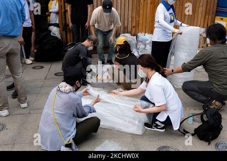 I membri del consiglio delle vittime di Sewol si esibiscono in altre opere d'arte, tra cui ritratti di vittime che sono stati esposti nello spazio della memoria di Sewol in Piazza Gwanghwamun il 27 luglio 2021 a Seoul, Corea del Sud. Il Consiglio delle vittime di Sewol ha concordato con il Governo Metropolitano di Seoul di esporre temporaneamente varie mostre, tra cui ritratti delle vittime presso l'ingresso principale della Sala dell'Assemblea Metropolitan di Seoul. Il nuovo spazio commemorativo è ancora in discussione. Il disastro del traghetto di Sewol al largo della costa sud-occidentale della Corea ha causato 304 vittime, per lo più studenti delle scuole superiori in viaggio educativo. (Pho Foto Stock