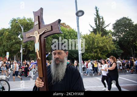 Un sacerdote porta una croce con Gesù durante la manifestazione. Centinaia di persone, meno del grande raduno precedente, si vedono alla dimostrazione contro il vaccino obbligatorio che si è tenuta a Salonicco in Grecia mercoledì 28 luglio 2021. Una settimana dopo la massiccia protesta contro la vaccinazione obbligatoria, la campagna anti-vaxx continua con un grande gruppo che protesta nelle strade della città di Salonicco. La protesta è stata organizzata attraverso i social media da credenti anti-vaccinazioni. Secondo il gruppo hanno partecipato più di 5000 persone, mentre la polizia ha stimato che non ufficialmente scivola Foto Stock