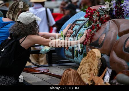 La gente posiziona le mani su un palo totem in preghiera durante una benedizione della scultura intagliata a mano che è stata trasportata attraverso il paese dallo stato di Washington a Washington, D.C. il palo totem era parte di un raduno sul centro commerciale nazionale il 29 luglio, 2021 per attirare l'attenzione e l'azione sui siti sacri e sui diritti indigeni (Foto di Bryan Olin Dozier/NurPhoto) Foto Stock