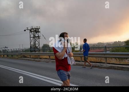 Un residente locale guarda come un incendio boschivo infuria a Varybobi, a nord di Atene, il 3 agosto 2021. Le aree residenziali della periferia settentrionale di Atene sono state evacuate quando gli incendi hanno raggiunto la periferia della città. La Grecia sta subendo la peggiore ondata di caldo degli ultimi decenni con temperature che raggiungeranno i 45C°C. (Foto di Gerasimos Koilakos/NurPhoto) Foto Stock