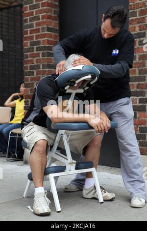 L'uomo riceve un massaggio Shiatsu fuori sul marciapiede a Toronto, Ontario, Canada, il 07 agosto, 2010. (Foto di Creative Touch Imaging Ltd./NurPhoto) Foto Stock