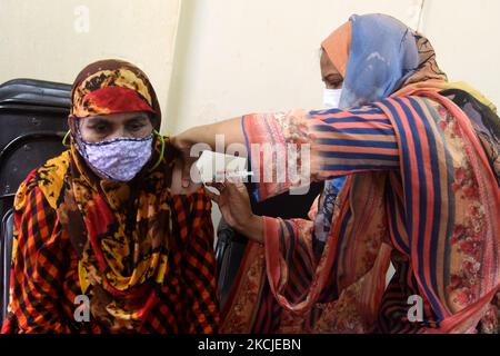 Una donna riceve uno shot del vaccino moderna COVID 19 durante una campagna di vaccinazione di massa presso un centro di vaccinazione a Dhaka, Bangladesh, 9 agosto 2021 (Foto di Mamunur Rashid/NurPhoto) Foto Stock