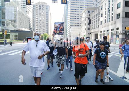 Jamal Johnson porta un segno di protesta chiedendo che smettiamo di ucciderci a vicenda e raffiguriamo le vittime della violenza delle armi mentre marciiamo lungo Market Street sulla prima tappa di una passeggiata da Filadelfia a Washington DC per chiedere al Congresso di passare la George Floyd Justice in Policing Act e. Affrontare la violenza delle armi, a Philadelphia, PA, il 9 agosto 2021. (Foto di Cory Clark/NurPhoto) Foto Stock