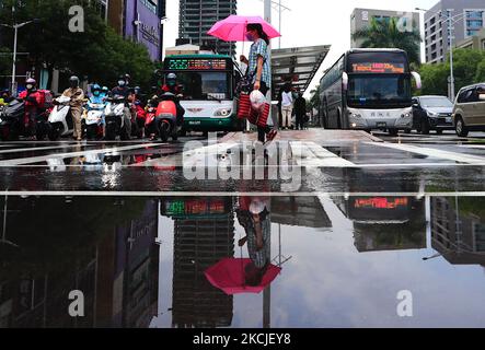 Le persone con maschere facciali attraversano una zebra che attraversa la zona del centro di Taipei, a seguito della recrudescenza di un recente focolaio e delle difficoltà nella fornitura di vaccini, a Taipei, Taiwan, 10 agosto 2021. Il paese di Yeh ha attualmente AstraZeneca, vaccini Moderna disponibili per la vaccinazione, mentre ha abbassato il suo allarme Covid al livello 2 con i controlli alle frontiere ancora in vigore. (Foto di Ceng Shou Yi/NurPhoto) Foto Stock