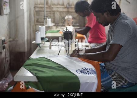 I lavoratori sono impegnati a stitching le bandiere come sono molto occupati durante l'ultima preparazione di tempo di fare le bandiere nazionali richieste per la celebrazione della Giornata dell'Indipendenza indiana il 15th agosto 2021. A causa della recente pandemia le istituzioni educative sono completamente chiuse e questo ha colpito un po' questo business. Le forniture materiali sono ancora in esaurimento, poiché il paese ha assistito a un recente blocco per frenare la diffusione del coronavirus. 12th agosto 2021, Kolkata, Bengala Occidentale, India (Foto di Sukhomoy Sen/NurPhoto) Foto Stock