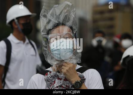 I manifestanti la coprono con una borsa di plastica durante la manifestazione a Bangkok il 13 agosto 2021. La polizia di Bangkok ha sparato proiettili di gomma e gas lacrimogeni contro i manifestanti pro-democrazia che chiedevano al primo ministro, Prayut Chan-o-cha di scendere e il governo di essere ritenuto responsabile per la sua cattiva gestione della pandemia del Covid-19. (Foto di Chaiwat Subprasom/NurPhoto) (Foto di Chaiwat Subprasom/NurPhoto) Foto Stock