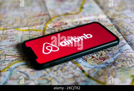 Il logo Airbnb visualizzato sullo schermo di un telefono e una mappa di Cracovia sono visti in questa foto di illustrazione scattata a Cracovia, Polonia il 17 agosto 2021. (Foto di Jakub Porzycki/NurPhoto) Foto Stock