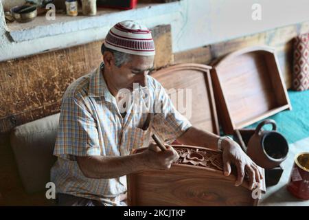 L'artigiano Kashmiri lucida un cassetto di noce intagliato a mano in un piccolo laboratorio galleggiante sul lago dal a Srinagar, Kashmir, India, il 26 giugno 2010. (Foto di Creative Touch Imaging Ltd./NurPhoto) Foto Stock