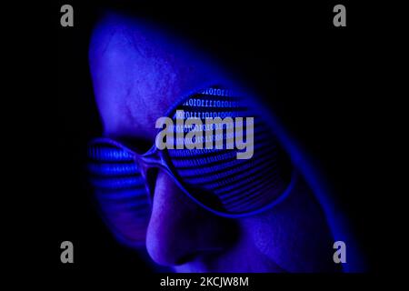 Il codice binario visualizzato sullo schermo di un computer portatile si riflette negli occhiali da sole in questa foto dell'illustrazione scattata a Cracovia il 17 agosto 2021. (Foto di Jakub Porzycki/NurPhoto) Foto Stock