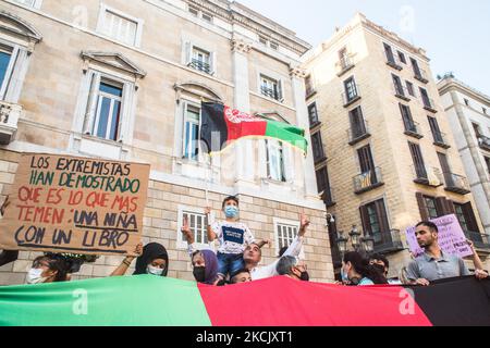 Un bambino è visto con una bandiera afghana accanto a manifestanti dietro una bandiera afghana e un segno che dice, gli estremisti hanno mostrato ciò che più temono: Una ragazza con un libro. Circa cinquecento persone hanno manifestato a Barcellona in solidarietà con le ragazze e le donne dell'Afghanistan e in difesa dei loro diritti sotto lo slogan "Afghanistan: Per una vita dignitosa e libera" (Photo by DAX Images/NurPhoto) Foto Stock