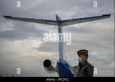 Un pilota di polizia colombiano e un aereo dietro come Yamit picon Rodriguez alias 'CHONCHA' Henry Trigos Celon alias 'HENRY' sia dell'ELN Guerrilla e Alexander Montoya Usuga alias 'El Flaco' del Golfo Clan 'Clan del Golfo' sono scortati dalla polizia Interpol e dalla polizia colombiana prima della loro estradizione Negli Stati Uniti, nella base militare CATAM di Bogotà, Colombia, il 19 agosto 2021. (Foto di Sebastian Barros/NurPhoto) Foto Stock