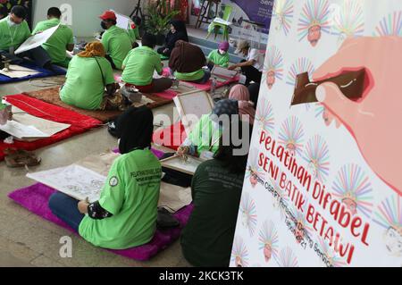 Le persone con disabilità sono addestrate in batik nella sala dell'edificio Balai Pustaka, Palmeriam, Matraman, Giacarta Est, Indonesia il 24 agosto 2021. Nell'attività ai partecipanti è stato insegnato come fare batik con cantare. Hanno fatto parecchie immagini quali le mascotte e i carri di perforazione di petrolio, ondel-ondel, Monas e così via. Tutti i partecipanti sono residenti e studenti del Distretto di Matraman che hanno esigenze particolari. L'evento è programmato per durare fino a mercoledì. Tuttavia, se possibile, continuerà per 24 giorni. (Foto di Dasril Roszandi/NurPhoto) Foto Stock