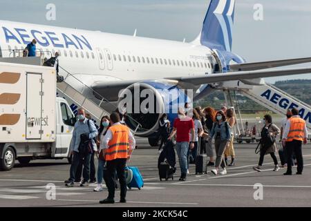 I passeggeri sbarcheranno di un Aegean Airlines Airbus A320neo a piedi verso il terminal dell'aeroporto dopo un volo nazionale da Atene, mentre sono visti indossare maschere protettive per il viso a causa della pandemia di Coronavirus Covid-19 all'aeroporto internazionale di Salonicco Makedonia SKG LGTS. La Grecia ha individuato la mutazione del Delta in giugno e oggi questa variante di Covid è la maggior parte dei casi, il paese ha imposto nuove misure e blocchi locali cercando di rilanciare il programma di vaccinazione pure. L'aeroporto di Salonicco è di proprietà del governo greco, ma è gestito con un contratto di locazione a lungo termine da Fraport Greece, subsi Foto Stock