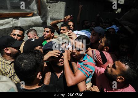 I lutto portano il corpo del palestinese Osama Deeij, che è morto di una ferita che ha sostenuto durante una protesta anti-Israele alla recinzione di confine Israele-Gaza il Sabato, durante il suo funerale nella striscia di Gaza settentrionale 25 agosto 2021. (Foto di Majdi Fathi/NurPhoto) Foto Stock