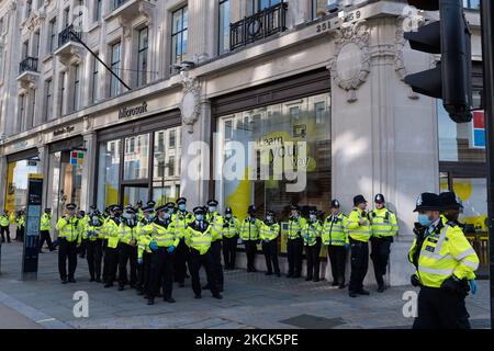 LONDRA, REGNO UNITO - 25 AGOSTO 2021: Un grande gruppo di poliziotti si prepara a rimuovere attivisti ambientali dalla rivolta di estinzione bloccando Oxford Circus il terzo giorno della 'ribellione impossibile', Una nuova ondata di proteste e azioni di disobbedienza civile ha previsto di continuare per almeno due settimane per chiedere un arresto immediato di tutti i nuovi investimenti nei combustibili fossili da parte del governo britannico e delle società finanziarie in un contesto di crisi climatica e di emergenza ecologica il 25 agosto 2021 a Londra, Inghilterra. (Foto di Wiktor Szymanowicz/NurPhoto) Foto Stock