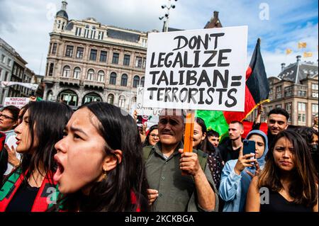 Un uomo sta tenendo un cartello contro il regime talebano mentre la gente grida slogan contro gli Stati Uniti e il regime talebano, durante la manifestazione a sostegno dell'Afghanistan che si terrà ad Amsterdam il 28th agosto 2021. (Foto di Romy Arroyo Fernandez/NurPhoto) Foto Stock