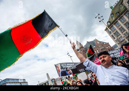 Un uomo sta tenendo una grande bandiera afghana, durante la manifestazione a sostegno dell'Afghanistan che si terrà ad Amsterdam il 28th agosto 2021. (Foto di Romy Arroyo Fernandez/NurPhoto) Foto Stock