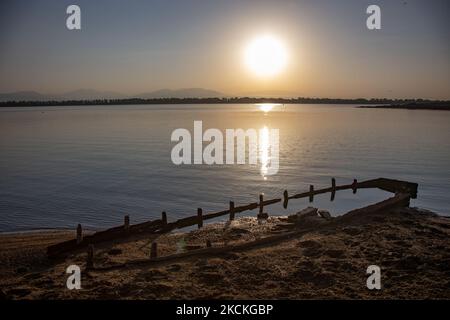 Vecchia barca da pesca affondata. Ora magica alba estiva con colori caldi del cielo e il sole su Kerkini con uccelli, cavalli, pescatori locali di pesca macchiati come silhouette, al Parco Nazionale del Lago nella regione di Serres nel nord della Grecia. Il lago artificiale Kerkini è una zona umida unica, un Parco Nazionale e protetta dalla Convenzione di Ramsar come zona umida con migliaia di uccelli, tra cui la foresta rara e protetta lungo il fiume, in quanto si stanno sviluppando importanti idrobiosfere di grande importanza e accettazione a livello internazionale, La principale fonte d'acqua proveniente dal fiume Strymon proviene dalla Bulgaria. Lago Kerkini, Ser Foto Stock