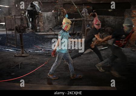 Tanim (12), durante i lavori in una fabbrica di riciclaggio del ferro a Dhaka, Bangladesh, il 30 agosto 2021. Lavora per 12 ore al giorno per guadagnare 20 dollari a settimana. (Foto di Syed Mahamudur Rahman/NurPhoto) Foto Stock