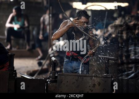 Un lavoratore durante una pausa dal lavoro in una fabbrica di riciclaggio del ferro a Dhaka, Bangladesh, il 30 agosto 2021. (Foto di Syed Mahamudur Rahman/NurPhoto) Foto Stock