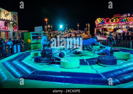 I ragazzi si divertono a saltare sopra l'ostacolo rotante il primo giorno dell'apertura del Luna Park a Molfetta il 4 settembre 2021. In occasione della Festa Patronale di Molfetta e in onore della Madonna dei Martiri, alla secca dei Pali è stato aperto il Luna Park, con cancelli di accesso e uscita, controllo della temperatura di accesso e controlli casuali del green pass secondo le istruzioni di legge. (Foto di Davide Pischettola/NurPhoto) Foto Stock