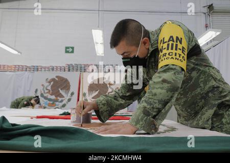 I membri del Segretariato della Difesa nazionale (SEDENA) dipingono la bandiera messicana disegnata su tessuto di nylon di alta qualità all'interno della fabbrica di abbigliamento e attrezzature El Vergel Iztapalapa, Città del Messico, A segnare la Gridò de Independencia e la Parata militare che si terrà il 15 e 16 settembre durante l'emergenza sanitaria dovuta al COVID-19 e al semaforo epidemiologico giallo nella capitale. (Foto di Gerardo Vieyra/NurPhoto) Foto Stock