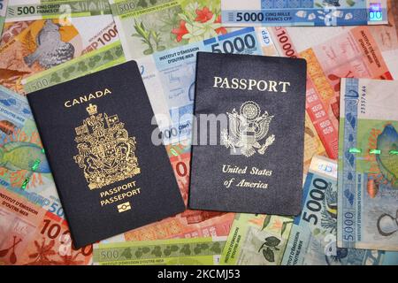 Passaporti provenienti dal Canada e dagli Stati Uniti d'America in cima ad un assortimento di banconote in franco del Pacifico francese a Toronto, Ontario, Canada. (Foto di Creative Touch Imaging Ltd./NurPhoto) Foto Stock