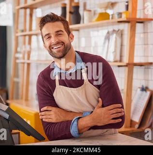 Questo è ciò che la soddisfazione del lavoro sembra. Ritratto di un felice imprenditore in posa dietro il bancone nel suo bar. Foto Stock