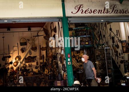 Saint-Ouen, Francia il 18 luglio 2021. Un uomo guarda l'antiquariato in un negozio al mercato Dauphine nel mercato delle pulci di Saint-Ouen. I vari mercati riuniscono quasi 2.000 commercianti e coprono 7 ettari. E' il più grande mercato d'arte e d'antiquariato del mondo, con 5 milioni di visitatori all'anno. Foto Stock