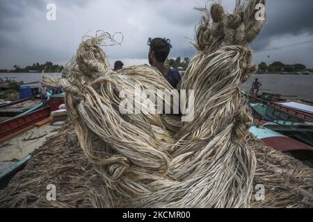 I lavoratori caricano la iuta su una barca sulla riva del fiume Padma in un mercato rurale a Munshigonj il 17 settembre 2021. (Foto di Ahmed Salahuddin/NurPhoto) Foto Stock