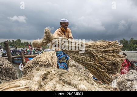 I lavoratori caricano la iuta su una barca sulla riva del fiume Padma in un mercato rurale a Munshigonj il 17 settembre 2021. (Foto di Ahmed Salahuddin/NurPhoto) Foto Stock