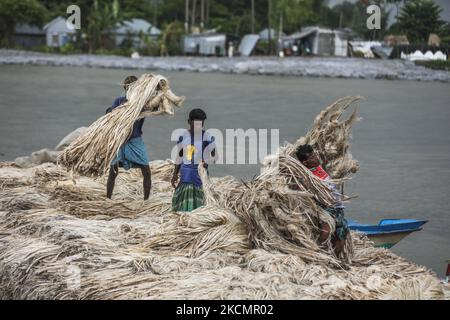 I lavoratori caricano la iuta su una barca sulla riva del fiume Padma in un mercato rurale a Munshigonj il 17 settembre 2021. (Foto di Ahmed Salahuddin/NurPhoto) Foto Stock