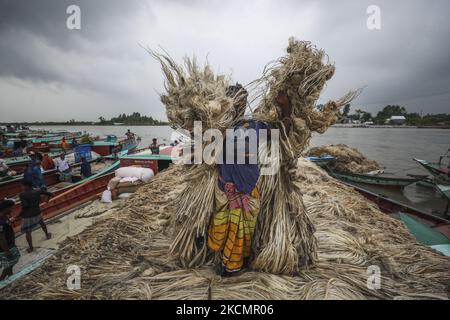 I lavoratori caricano la iuta su una barca sulla riva del fiume Padma in un mercato rurale a Munshigonj il 17 settembre 2021. (Foto di Ahmed Salahuddin/NurPhoto) Foto Stock