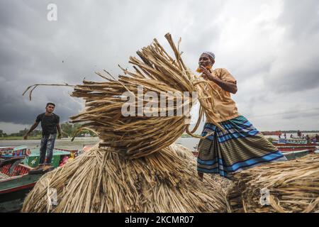 I lavoratori caricano la iuta su una barca sulla riva del fiume Padma in un mercato rurale a Munshigonj il 17 settembre 2021. (Foto di Ahmed Salahuddin/NurPhoto) Foto Stock