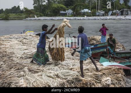 I lavoratori caricano la iuta su una barca sulla riva del fiume Padma in un mercato rurale a Munshigonj il 17 settembre 2021. (Foto di Ahmed Salahuddin/NurPhoto) Foto Stock