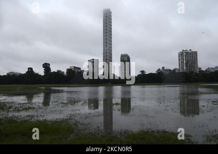 Il riflesso di un alto edificio può essere visto su un campo allagato a causa di forti precipitazioni a Kolkata, India, 20 settembre, 2021. (Foto di Indranil Aditya/NurPhoto) Foto Stock