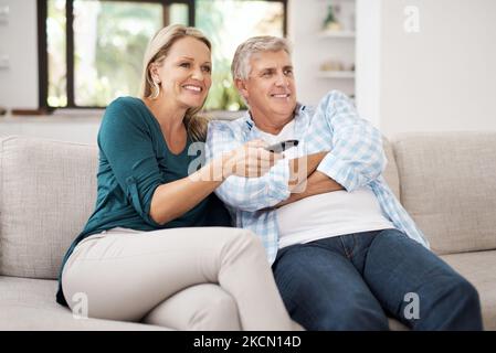 Pronto per iniziare il film. Una coppia affettuosa matura che guarda la televisione insieme a casa. Foto Stock