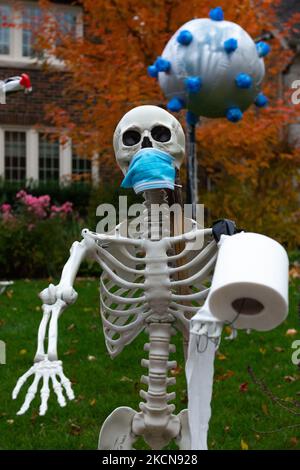 Toronto, ON, Canada – 25 ottobre 2020: Lo scheletro indossa una maschera facciale sul lato anteriore della casa come decorazione di Halloween a Toronto. (Foto di Anatoliy Cherkasov/NurPhoto) Foto Stock