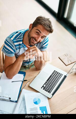 Im che punta al top. Ritratto ad angolo alto di un bel giovane imprenditore maschio che lavora dal suo ufficio di casa. Foto Stock