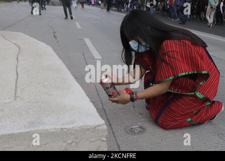 Una donna della comunità indigena Triqui fa alcuni graffiti nello spazio pubblico mentre marciava dall'Angelo dell'Indipendenza allo Zocalo a Città del Messico, per chiedere giustizia e punizione per i 43 studenti dispersi di Ayotzinapa, Guerrero, il 26 settembre 2014. (Foto di Gerardo Vieyra/NurPhoto) Foto Stock